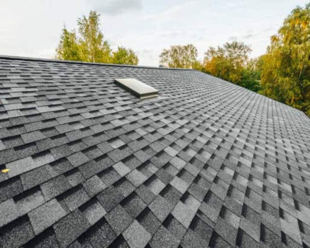 roof of new house with shingles roof-tiles and ventilation window